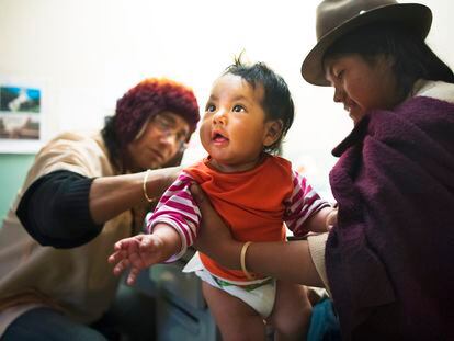 Una mujer sostiene a su bebé durante una consulta médica en Ecuador.