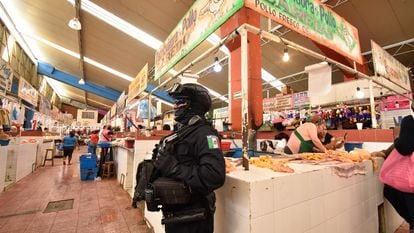 Un policía resguarda puestos de pollo en Chilpancingo (Guerrero), luego del asesinato de ocho comerciantes en junio de 2022.