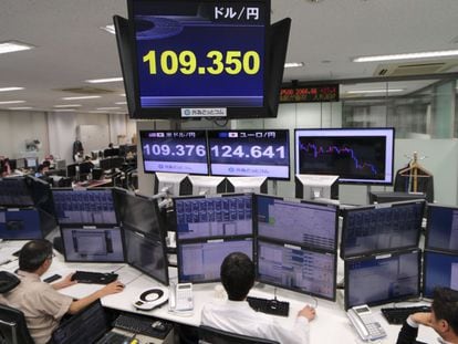 Varios operadores japoneses trabajan delante de pantallas que marcan el tipo de cambio entre el yen y el d&oacute;lar estadounidense. 