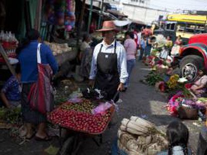 Un hombre ofrece frutas en el Mercado "La Terminal", en la Ciudad de Guatemala, durante la conmemoración del Día Internacional del Trabajo.