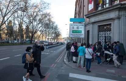 Los padres y madres de alumnos esperan la salida de los alumnos del colegio público Palacio Valdés, en el paseo del Prado de Madrid.