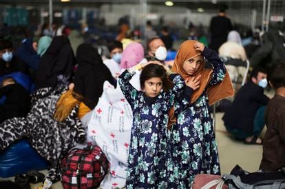 Dos niñas afganas evacuadas del país esperan la llegada de otros compatriotas en un hangar de la base aérea esatadounidense en Ramstein, Alemania.