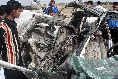Varios iraquíes observan el coche en el que viajaba el director de los servicios de Inteligencia de la provincia de Maisun.