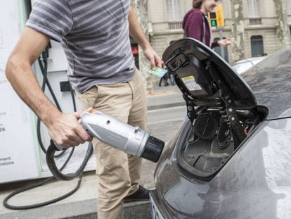 Un conductor carga su coche el&eacute;ctrico en Barcelona. 