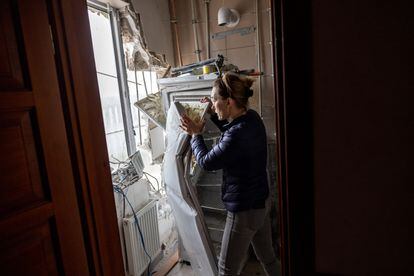 Una vecina de Gostomel, en la provincia de Kiev, busca este lunes entre los escombros de su vivienda objetos que pueda recuperar, tras ser alcanzada por cohetes rusos.