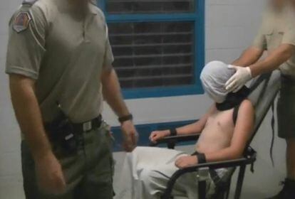 Fotograma del programa de investigación de la televisión australiana Four Corners que muestra a un muchacho con las manos y el cuello atados a una silla y la cabeza cubierta por una capucha en el centro de detención juvenil Don Dale, en Berrimah, Australia.