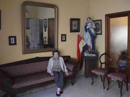María Luz Luis Illada, en su casa de Tenerife, con el retrato de sus familiares y la talla de la virgen.