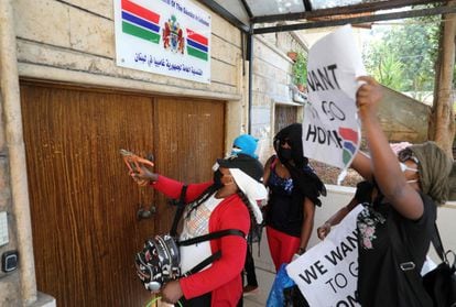 Varias trabajadoras migrantes de Gambia utilizan herramientas para llamar a la puerta del consulado de Gambia en Beirut el 20 de agosto de 2020 durante una protesta pidiendo ser evacuadas del Líbano y repatriadas a su país.