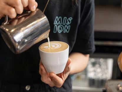 Un barista realiza 'latte art' sobre un café recién elaborado en Misión Café, en Madrid.