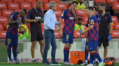 Barcelona's Spanish coach Quique Setien (C) speaks to players during a water break during the Spanish League football match between FC Barcelona and Club Atletico de Madrid at the Camp Nou stadium in Barcelona on June 30, 2020. (Photo by Lluis GENE / AFP)