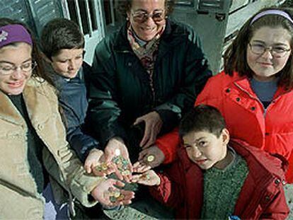 Un grupo de habitantes del municipio de La Acebeda (Madrid) muestra las diferentes monedas de euro.