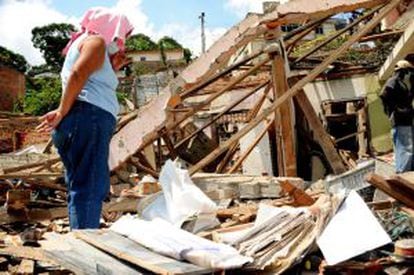 Fotografía cedida por el Diario Q'Hubo de una mujer mirando los escombros de las casas destruidas en el atentado de las FARC.