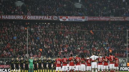 Los jugadores del Atlético de Madrid y del FC Bayern Munich, durante el minuto de silencio, antes del partido, en memoria de los miembros del equipo de fútbol brasileño Chapecoense.
