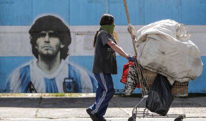 Un home passa davant d'un mural de Maradona, carregat amb les seves pertinences, a Buenos Aires.