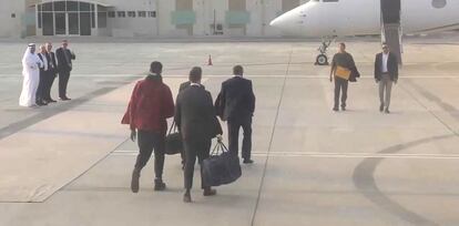El momento del intercambio de presos en el aeropuerto de Abu Dabi. Brittney Griner es la más alta, de espaldas, vestida de rojo. Viktor Bout está de frente con un sobre o una carpeta en la mano.