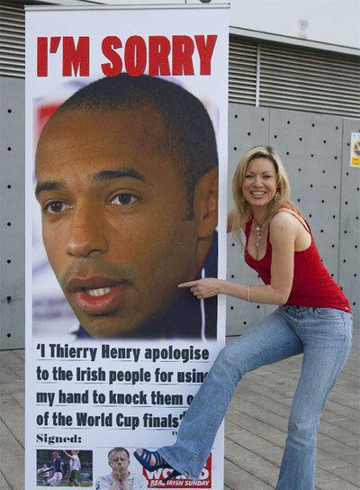 Una periodista, con un cartel de Henry en la ciudad deportiva del Barça.
