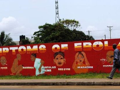 Un hombre camina frente a un mural sobre el ébola en Monrovia.