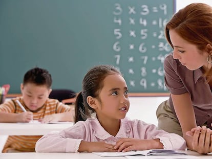 Una maestra dando clase a unos ni&ntilde;os.