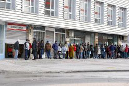 Varias personas forman una larga cola ante una oficina del INEM, a primera hora de la ma&ntilde;ana. 