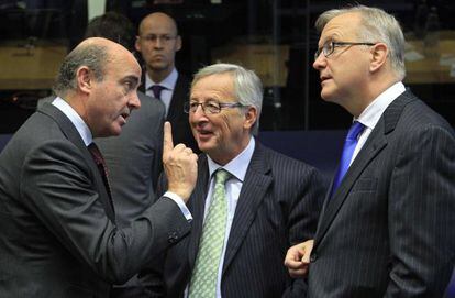 De izquierda a derecha, Luis de Guindos, Jean-Claude Juncker y Olli Rehn, durante una reuni&oacute;n en Luxemburgo en octubre.