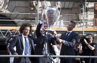 Los jugadores del Real Madrid Marcelo Vieira (i), Sergio Ramos (c) y Cristiano Ronaldo sostienen el trofeo en el exterior de la Casa de Correos en la Puerta del Sol.