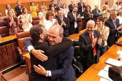El presidente andaluz abraza al portavoz socialista en el Parlamento regional tras la aprobación del texto.
