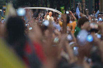 El papa Francisco saluda a la multitud desde el papam&oacute;vil en el recorrido que le llevar&aacute; al palacio de Guanabara.