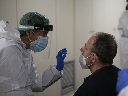 Una sanitaria toma una muestra para un test de antígenos en un punto de cribaje masivo en un barrio de Barcelona.