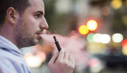 Un home fuma un cigarret electrònic en un carrer de Barcelona
