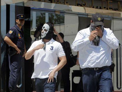 Dos de los acusados, con las caras ocultas, salen de la Audiencia de Madrid el pasado junio.