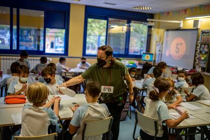 Una maestra dispensa gel desinfectante a los alumnos en el colegio Maestro Padilla de Madrid, este martes.