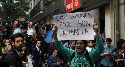 Un joven muestra una pancarta a las puertas de la sede del PSOE, en la madrileña calle Ferraz.