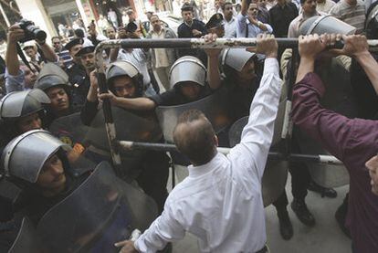 Opositores al presidente Hosni Mubarak se enfrentan a la policía egipcia en una protesta en El Cairo, el martes.