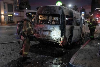 Bomberos trabajan alrededor de uno de los vehículos incendiados este viernes, en Tijuana.