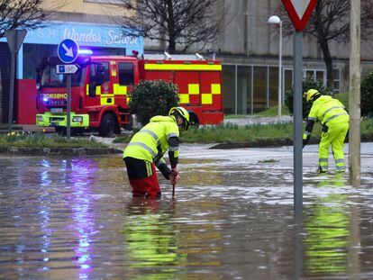 Dos bomberos trabajan en una vía inundada en Santiago de Compostela.