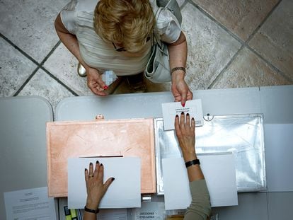 Una mujer deposita su voto para las elecciones generales en un colegio de Valencia.