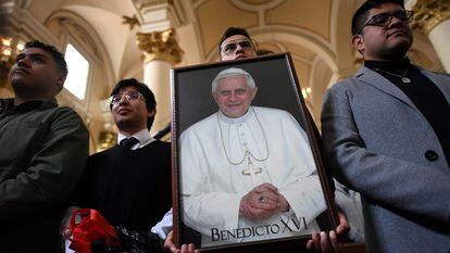 Un feligrés de Colombia sostiene una foto del papa Benedicto XVI.