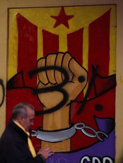 Un hombre sigue el mitin que Junts per Catalunya en la plaza Virreina de Barcelona.