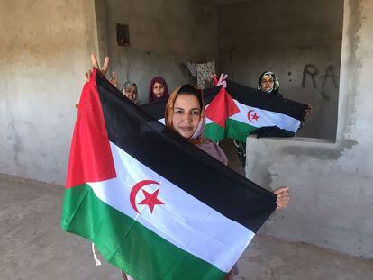 Sultana Jaya posa en su casa de Bojador con la bandera de la República Árabe Saharaui Democrática, acompañada de otras militantes pro Frente Polisario, este sábado.