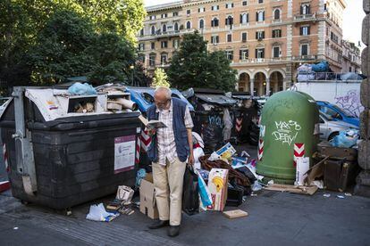 Un hombre lee rodeado de basura en el centro de Roma.