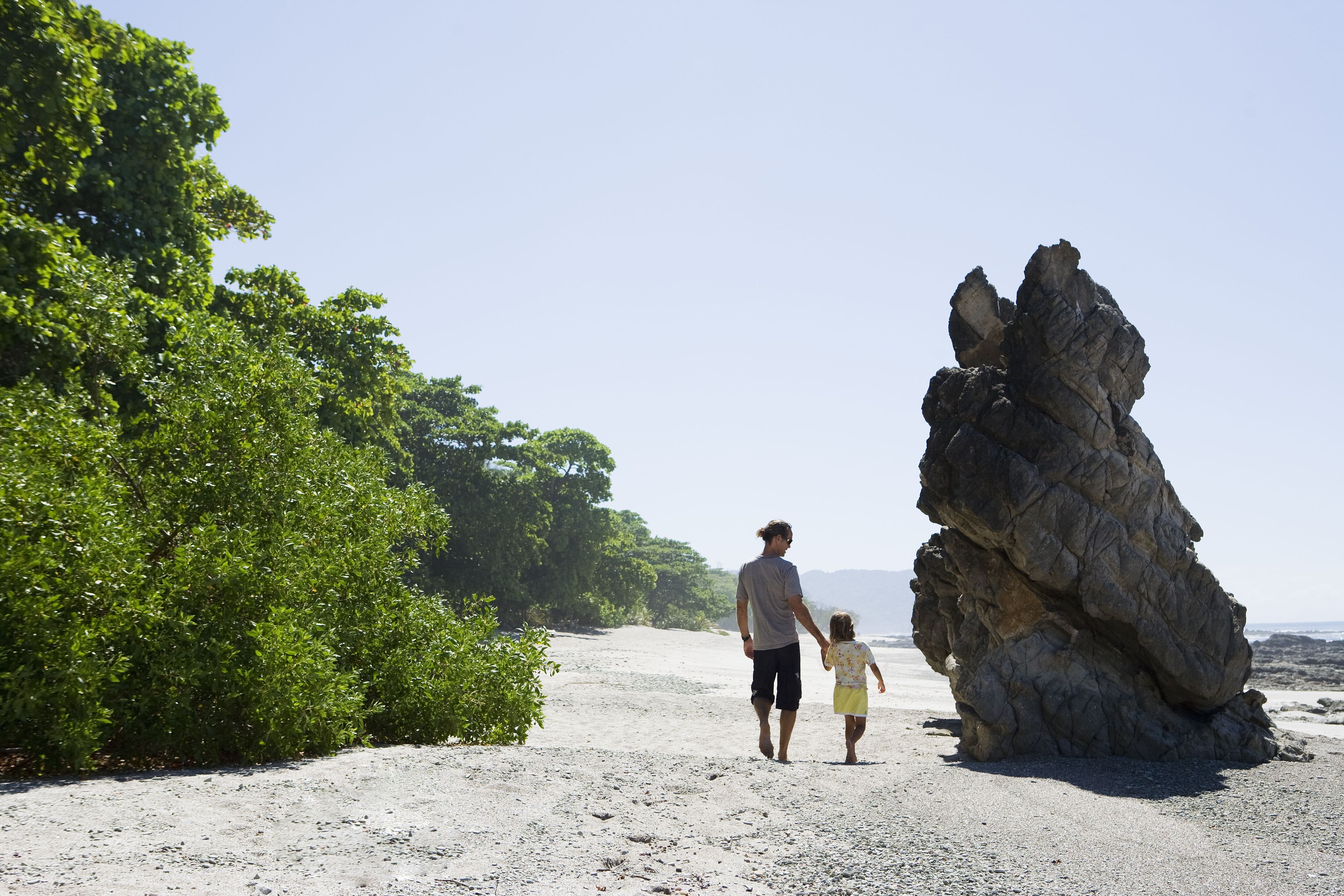 Un padre y su hija caminan por la playa de Santa teresa en Costa Rica. 