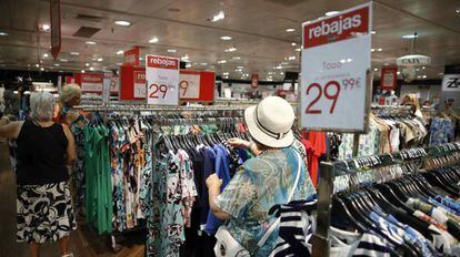 Varios clientes eligen entre los productos rebajados de un centro comercial en Madrid.