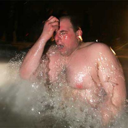Un hombre se da un chapuzón en agua helada durante las celebraciones por la Epifanía en Moscú.