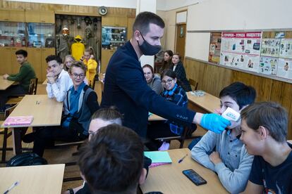 Una profesor mide la temperatura de un alumno en Moscú el 7 de septiembre.