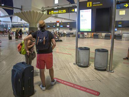 Pasajeros miran las pantallas informativas en la terminal de salidas del aeropuerto de San Pablo, Sevilla, el 19 de agosto.