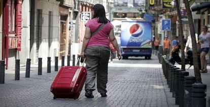 Una mujer recorre el centro de Madrid con su maleta.