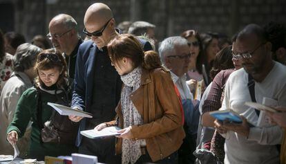 Curiosos ojean las paradas de libros durante Sant Jordi.