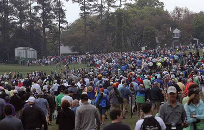 Los espectadores abandonan el campo de Augusta al suspenderse las prácticas del miércoles por la lluvia.