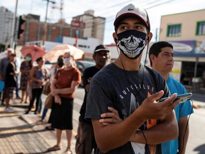 Un hombre espera para recibir un subsidio del Gobierno por la pandemia en São Paulo, Brasil.