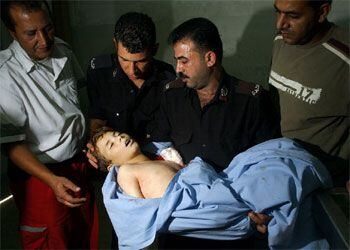 Un policía palestino lleva en brazos en un hospital de Nablús el cadáver del niño de nueve años Jaled Usta, muerto por disparos del Ejército israelí.